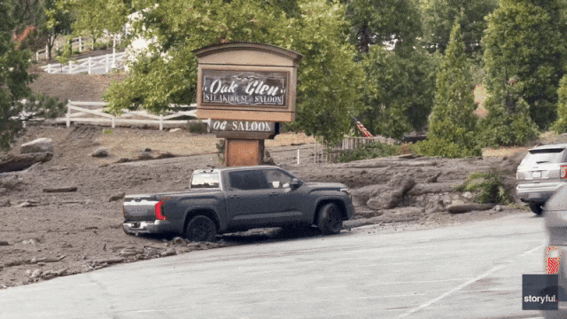 Watch: Woman trapped trying to save truck as wall of muddy water slams into California town