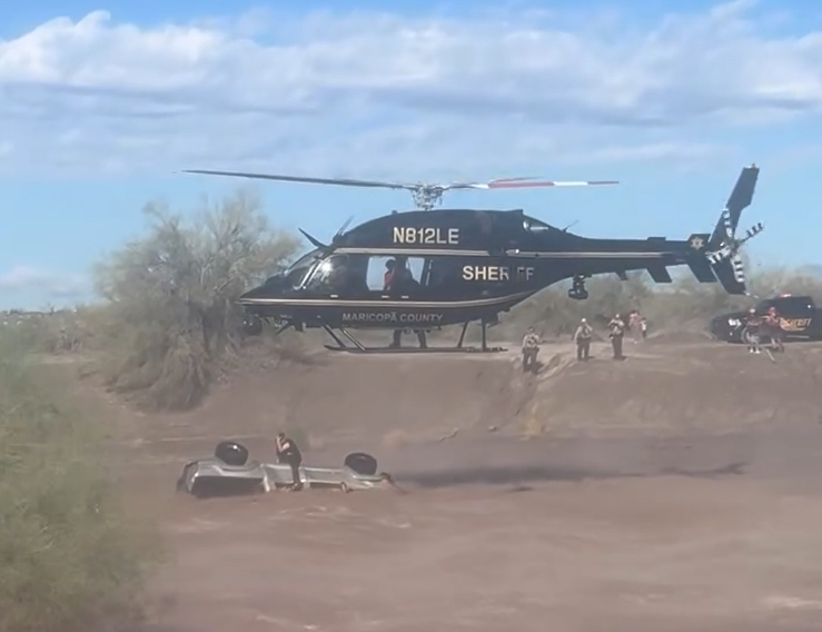 Responders rescue driver stranded on top of submerged car as strong floodwaters flow through Arizona